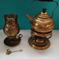 A Vintage Brass Heart Hurricane Lamp Candleholder And Antique Brass Tea Kettle, Teapot and complete warmer on a decorative stand.