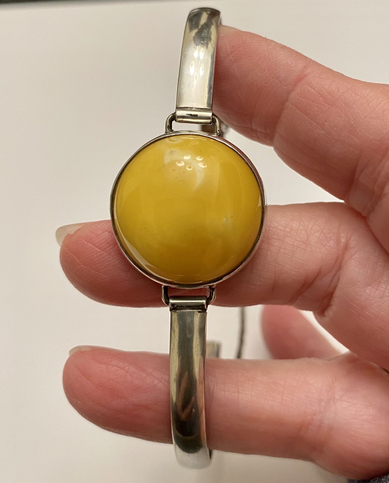 Antique Butterscotch Amber in Sterling Silver Bracelet With Safety Chain. The diameter of the amber is just under one inch. The width of the band is