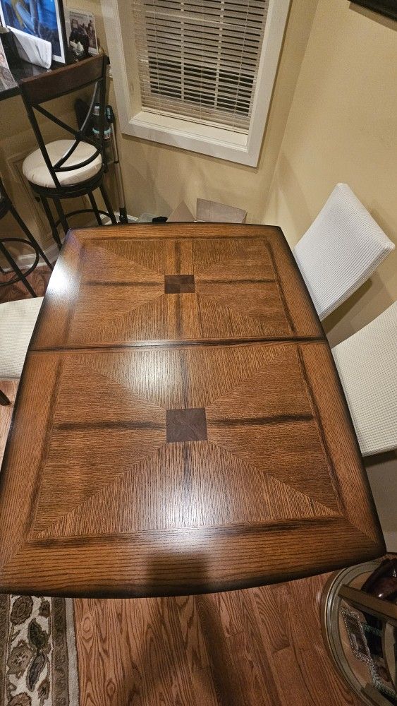 Red oak dinning room table with leaf and 4 faux leather chairs