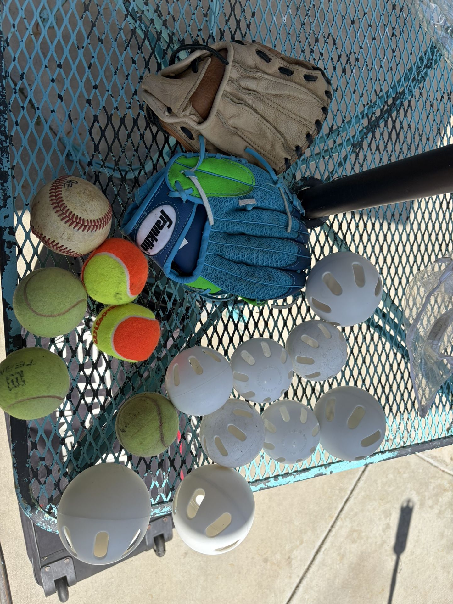 2 Kid Baseball Gloves And A Couple Of Tennis Balls And White Plastic Balls