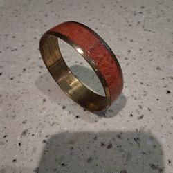 Vintage enameled brass bangle bracelet with reddish-orange inlay