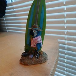 Macaw with a surfboard figurine