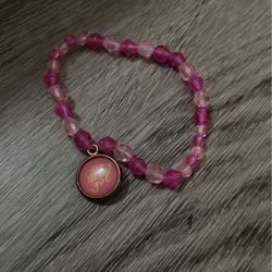 White and dark pink bracelet with charm that says you glow girl