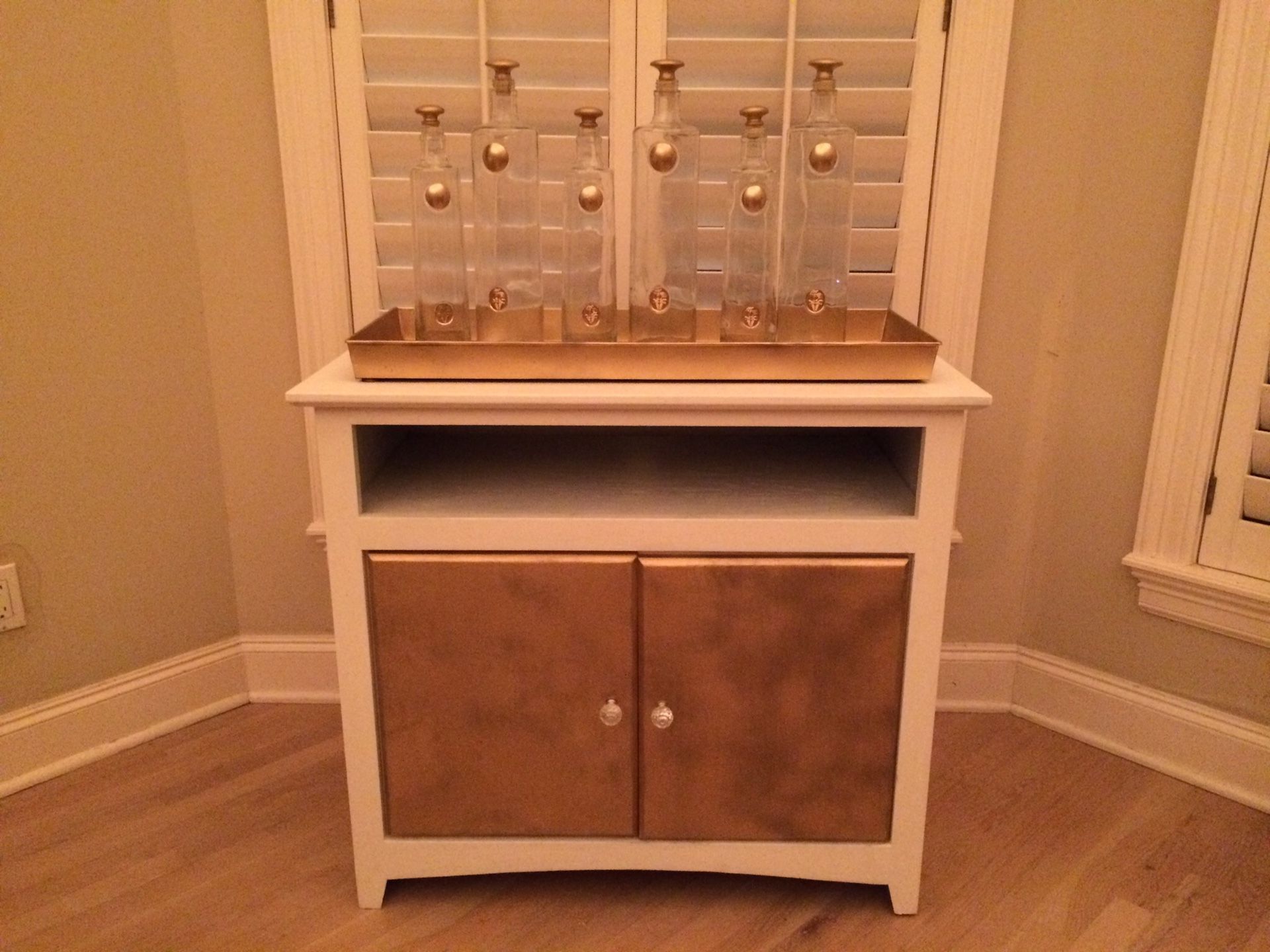 Gold and white bar with crystal knobs and wine rack installed
