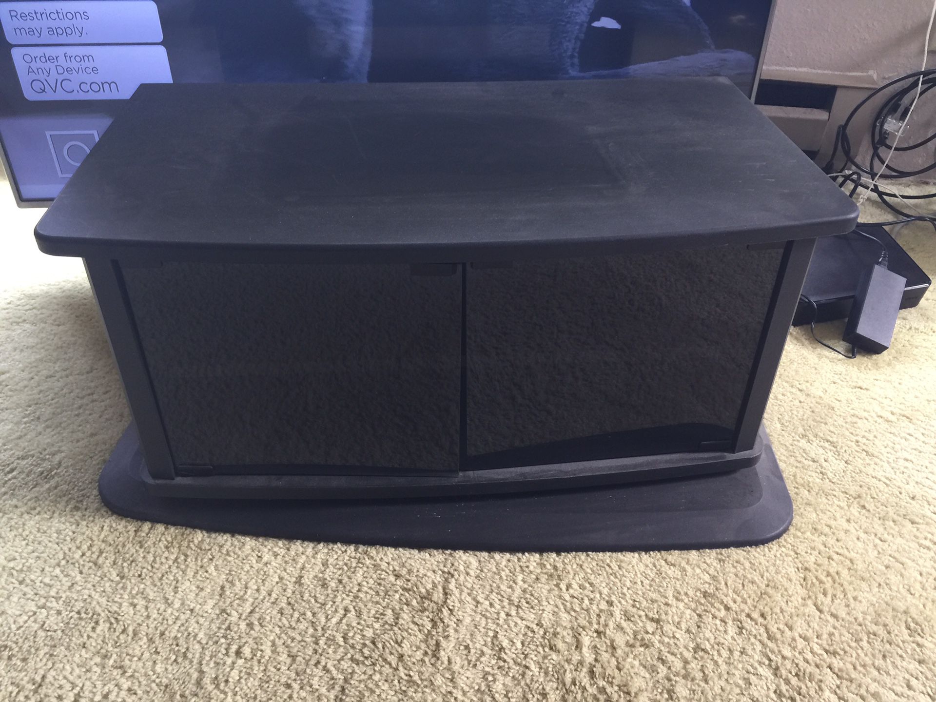 Swivel base tv stand, glass doors open to hold DVD player and tapes