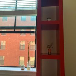 Two Ikea red bookshelves 