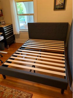 Queen bed frame with upholstered headboard.
