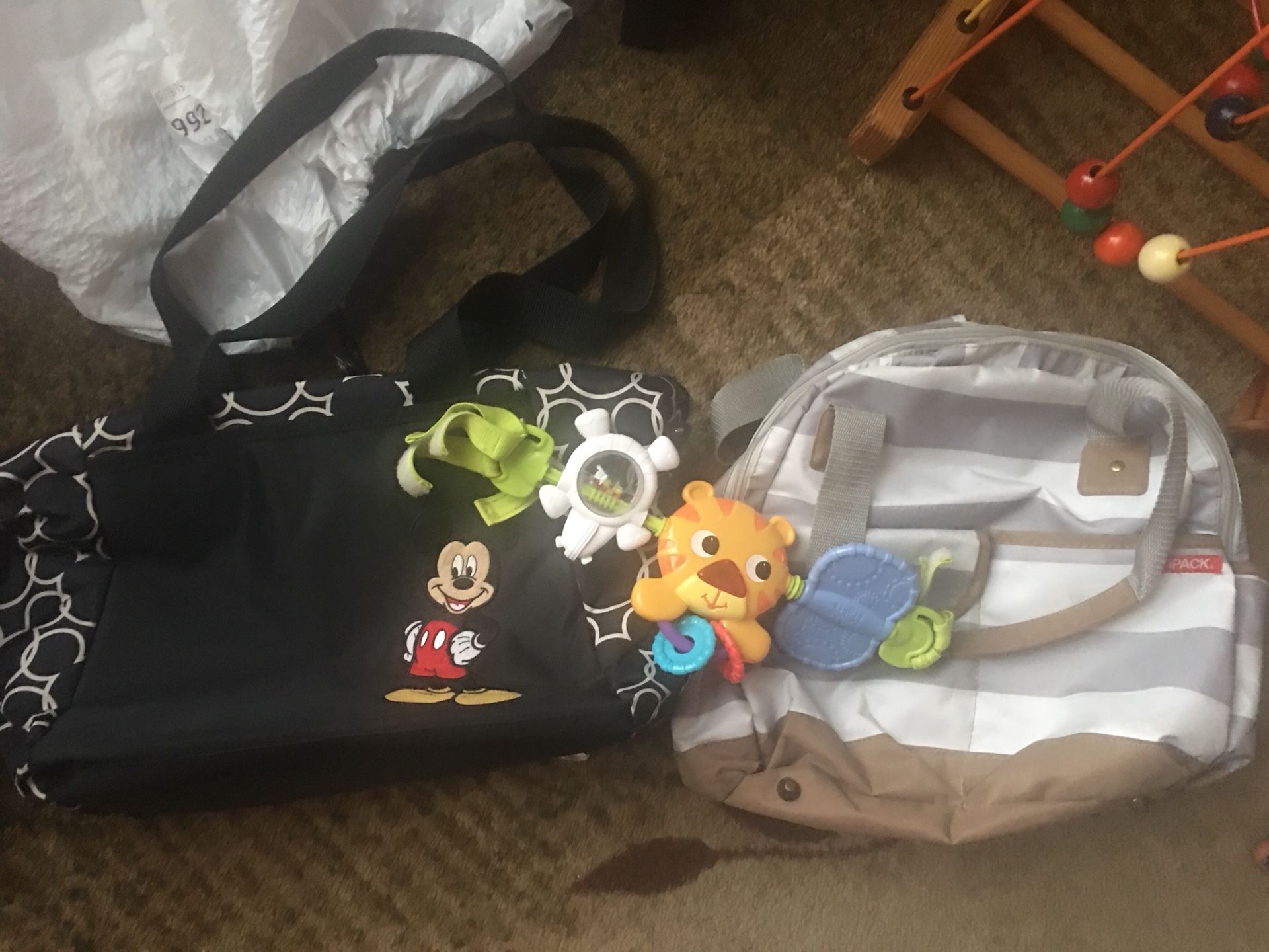 Two Diaper Bags And A Car Seat Toy