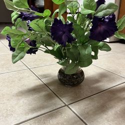 Beautiful artificial purple flower house plant in a nice glass bottom stand filled with rock and acrylic.