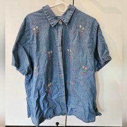 Denim button down shirt with floral embroidery and flower buttons.