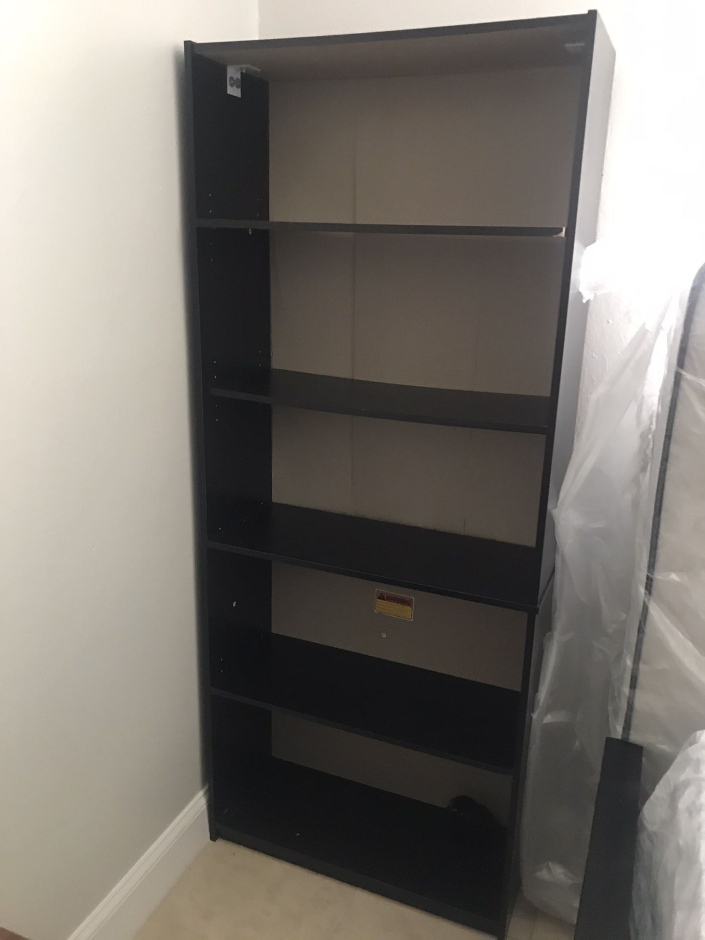 Three bookshelves one black and two wood colour $15 each or $30 for three of them