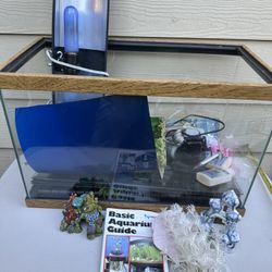 aquarium setup, including a glass tank, decorations (coral, plants), and a "Basic Aquarium Guide" booklet