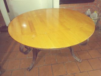 Solid wood coffee table with wrought iron base.