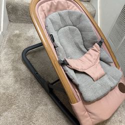 A modern baby bouncer from Maxi-Cosi, featuring a soft cushion and safety straps. It rocks gently in response to the baby's movements. It is equipped 