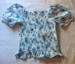 Blue floral print blouse with ruffled sleeves and hem