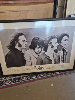 a framed 1991 Apple Corps print of The Beatles featuring black-and-white portraits of the band members
