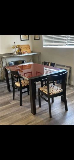 Dining table with four chairs the glass is  attached to the frame