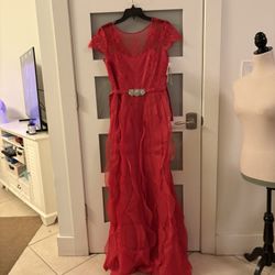 The outfit consists of a long skirt with a gold floral print and a purple chiffon blouse with ruffles joined by a floral belt featuring feathers and d