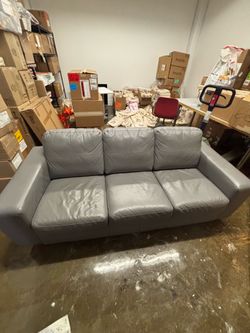 3 seat grey leather sofa and 2 blk si gel seat leather chairs.