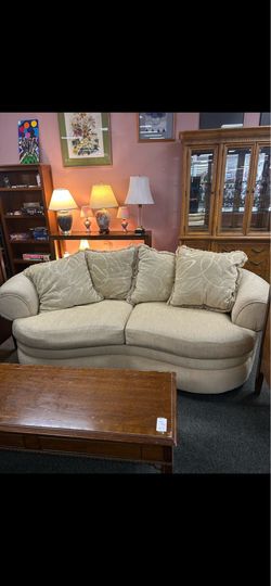 Curved Beige Upholstered Sofa with Throw Pillows