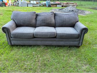 Brown sofa features rolled arms 86”