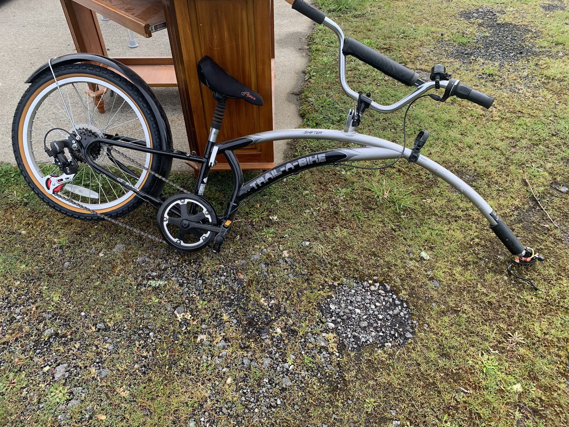 Trail a bike. To put behind your bike for a child that doesn’t know how to ride a bike.