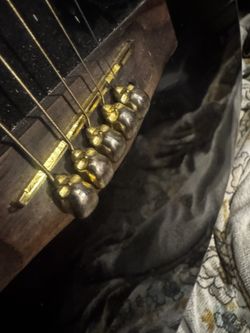 Ugly Black Guitar With Gold Skulls By Strings 