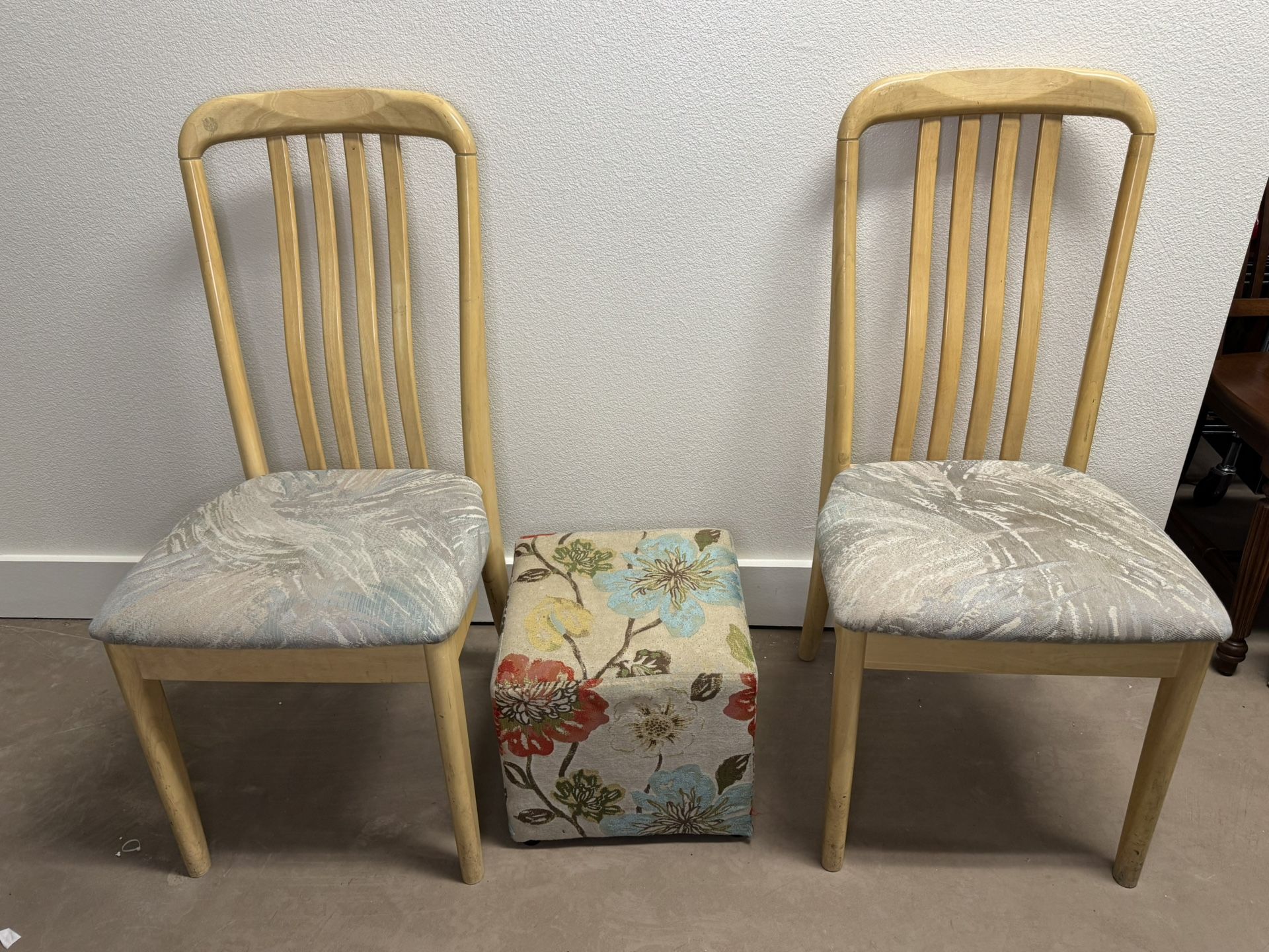 two wooden chairs and an ottoman