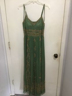 Green floor length dress with gold beading.