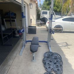 Bench press/squat rack with 255lbs of Olympic weights plus 7ft 45lbs bar