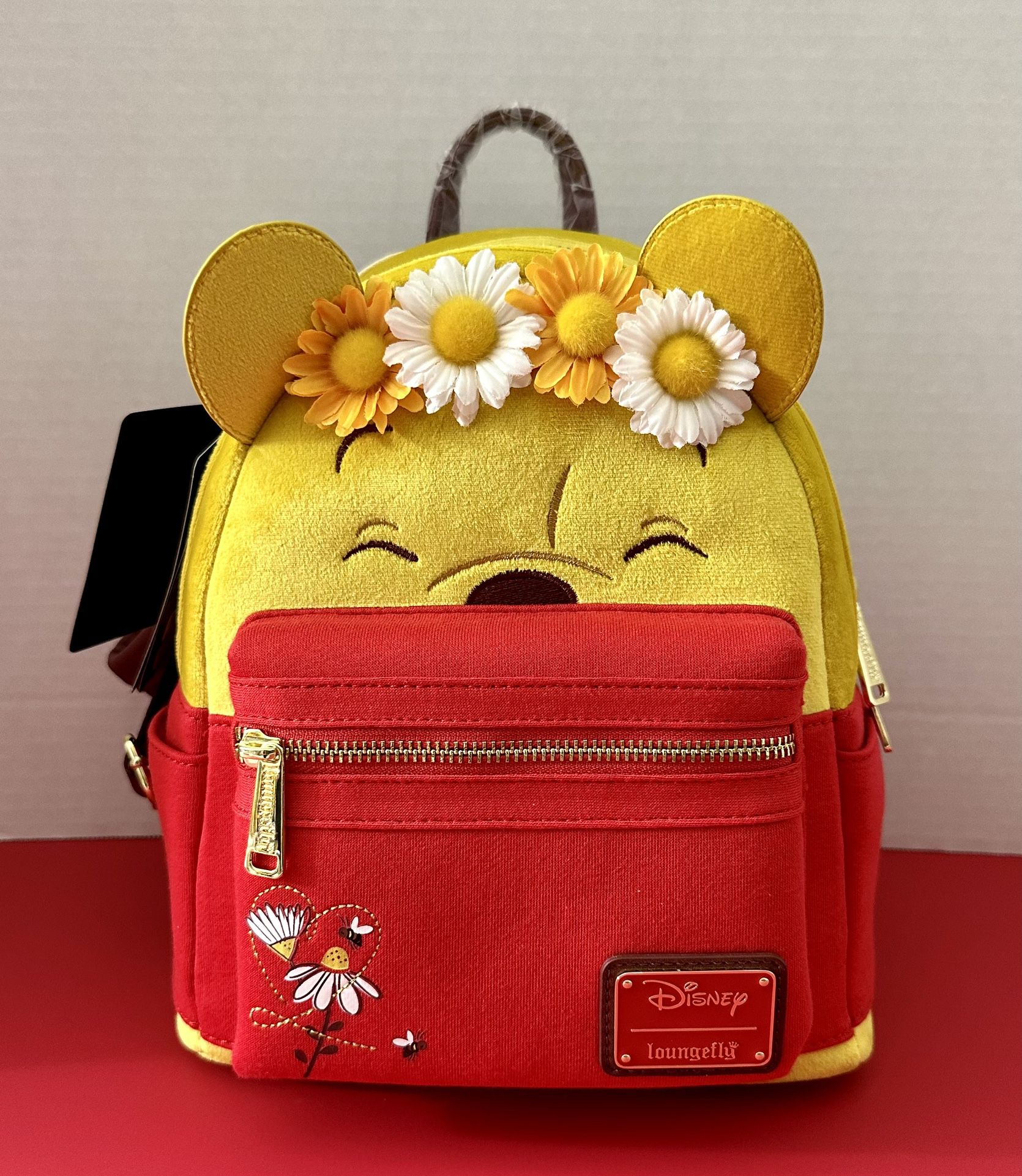 BRAND NEW WITH TAGS! DISNEY WINNIE THE POOH BEAR FLORAL CROWN FLOCKED LOUNGEFLY BACKPACK FOR SALE. 