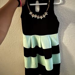 A Mint Green And Black Dress With A Necklace Attached 