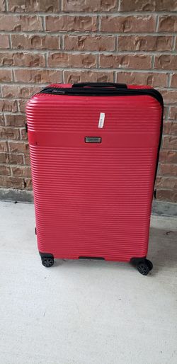 Kenneth Cole Reaction hardside suitcase features a vibrant red finish with horizontal ridged detailing