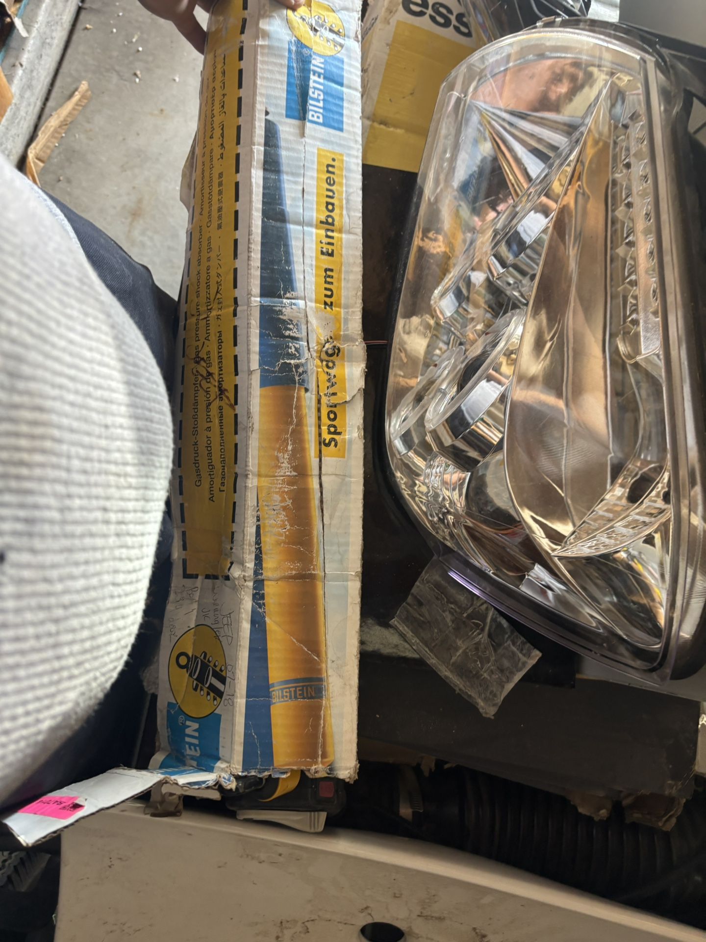 The image shows two products that are compatible with a 2007-2018 Jeep Wrangler JK: a Bilstein shock absorber and a headlight assembly. Bilstein Shock