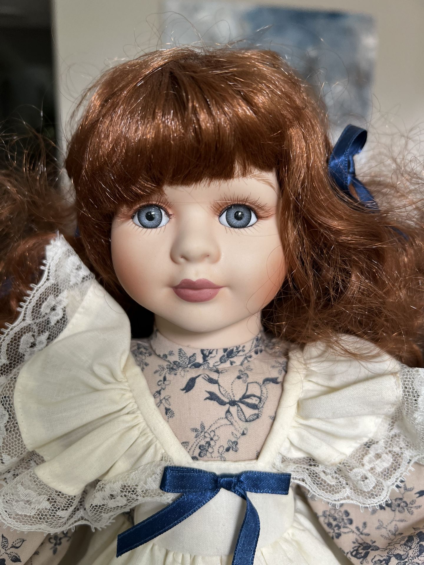 Geppeddo Doll Porcelain 16” Doll auburn hair, blue eyes stand w wooden base Measurements are approximate. Non-smoking no pet home. Please see all p