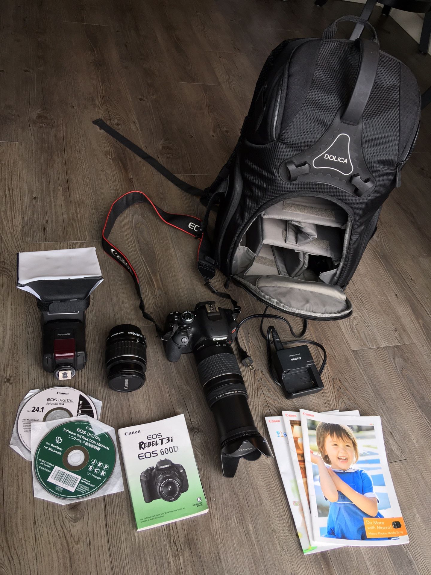 Canon EOS Rebel T3i with two lenses, Flash with diffuser, manuals, and camera backpack