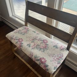 Wooden Bench. Distressed Brown Cushion Seats Two. Floral Print On Cushion.