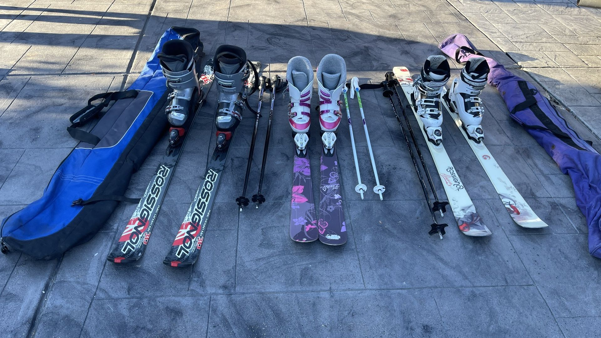 3 Sets Of Skis, Boots, Poles And Carrying Bags