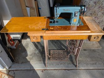 Antique treadle sewing machine in cabinet