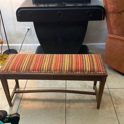 Vintage style piano bench featuring a striped upholstered cushion and straight wooden legs