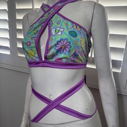 New floral-print crop top with a front keyhole cutout. Crisscross halter straps and wrap-around ties. Bright, colorful pattern for festivals or beachw