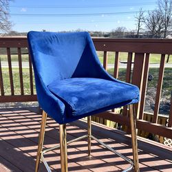 Blue velvet upholstered counter stool with polished gold metal legs and footrest. Excellent condition. Height: counter height. Sells fast—grab it!