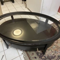 Coffee table: Black wooden coffee table with glass top and storage drawer $60