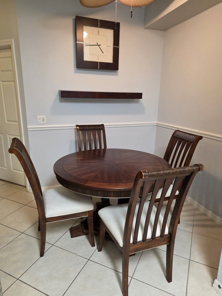 Round wooden dining table with a pedestal base.