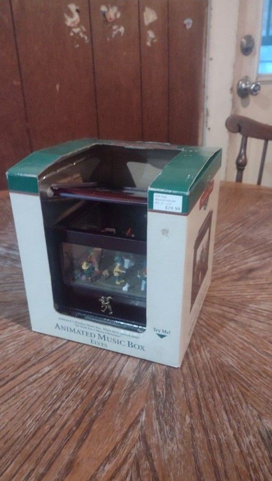 Mr. Christmas Music And Motion Animated Music Box Santa And Elves, from 1999 and measures 6" by 6" by 5"