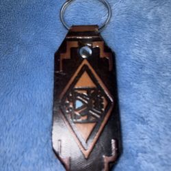 tooled leather key fob featuring a Southwestern or Aztec-style geometric pattern