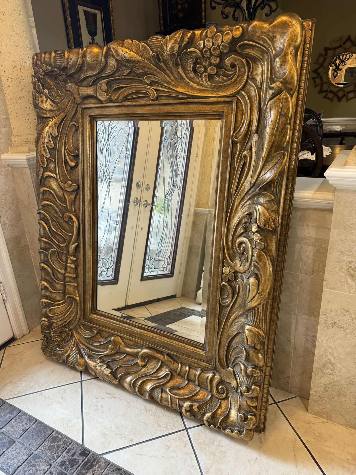 large Italian Gilt  ornate wall mirror with intricate carvings,  beveled edges and dental molding