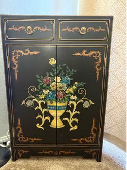 black lacquer Chinoiserie cabinet features hand-painted floral motifs and gilded lock hardware..