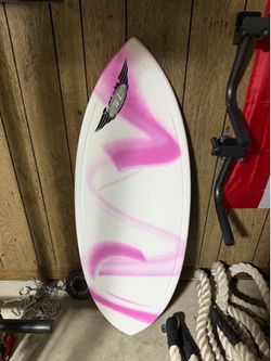Pink and white fiberglass skimboard