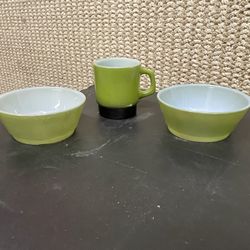 This set includes vintage Anchor Hocking Fire King milk glass items featuring an avocado green and black two-tone design, including stacking mugs and 